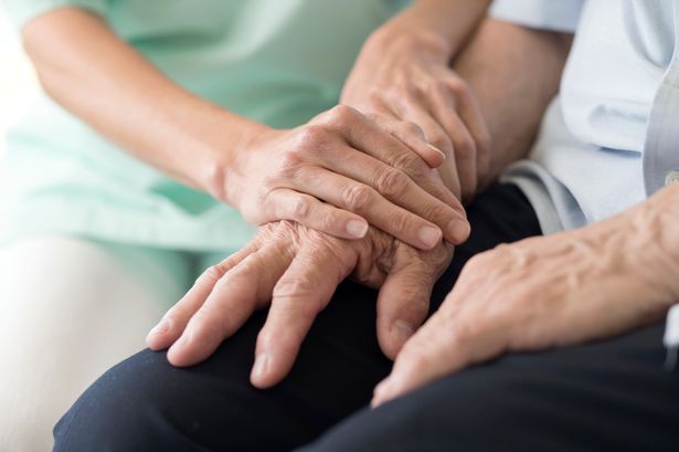 A carer holding the arm of someone who's receiving care 