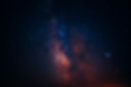 Starry night sky showing the Milky Way with vibrant blues and oranges. Dark, vast setting evokes wonder and serenity. No text visible.