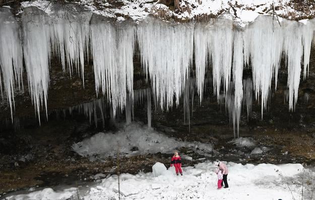 Hikers near a spot known as Šikľavá Skala between the villages of Chrasť nad Hornádom and Matejovce nad Hornádom in eastern Slovakia. In winter, a stunning 10-metre long frozen waterfall usually formes here due to freezing temperatures.