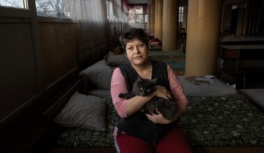 Anna and her cat Vinya inside the university shelter where they have been living since March 13, 2022 in Lviv, Ukraine on February 12, 2023. Anna's small village in the Donetsk district was destroyed, forcing her to flee and seek refuge. (Paula Bronstein for HIAS).