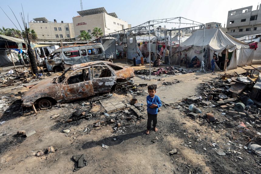 A boy looks on at the site of an Israeli strike on tents sheltering displaced people at Al-Aqsa hospital in Deir Al-Balah in the central Gaza Strip, October 15, 2024.