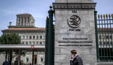 A man speaks on the phone on April 12, 2022, while entering the World Trade Organization (WTO) headquarters in Geneva.