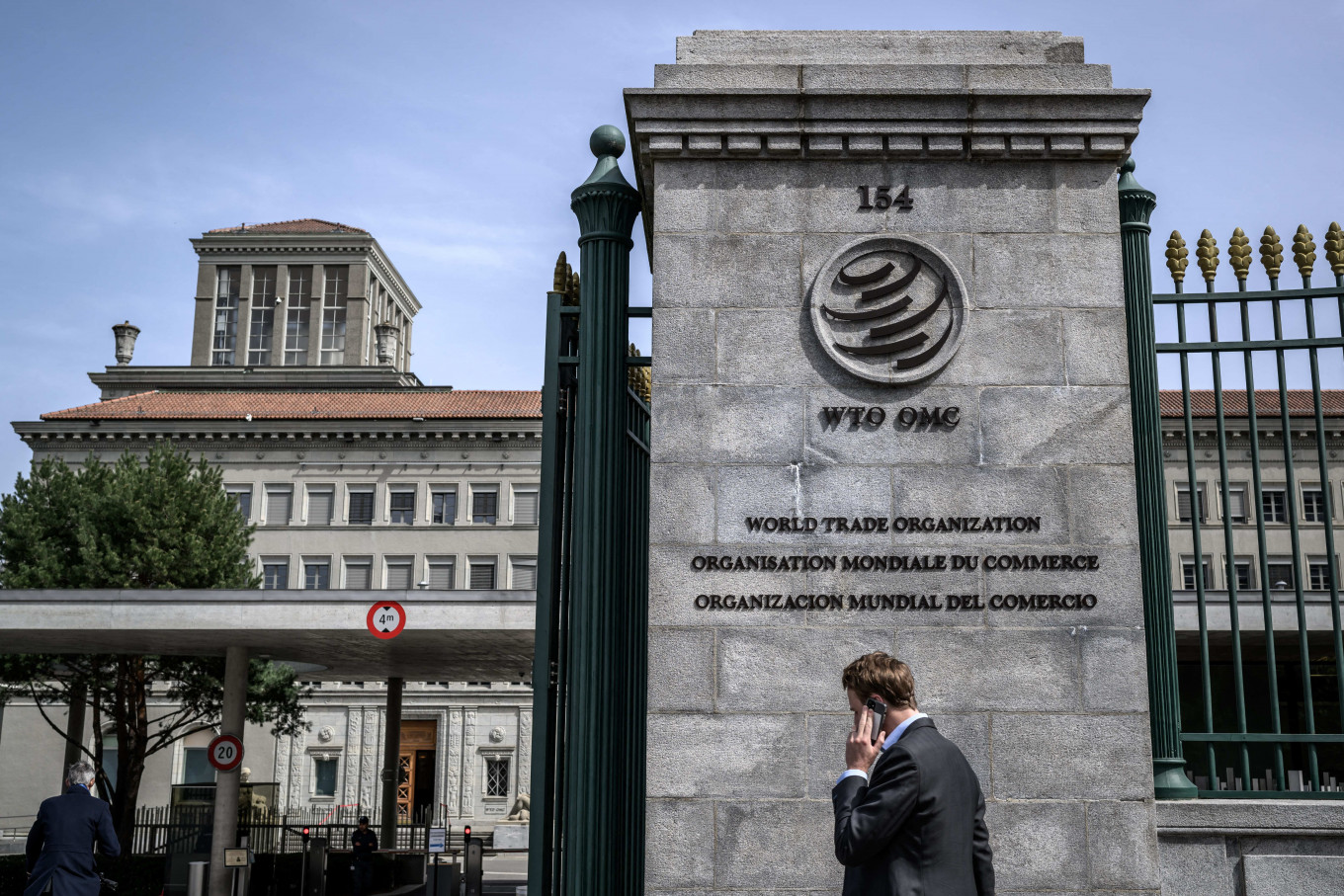 A man speaks on the phone on April 12, 2022, while entering the World Trade Organization (WTO) headquarters in Geneva.