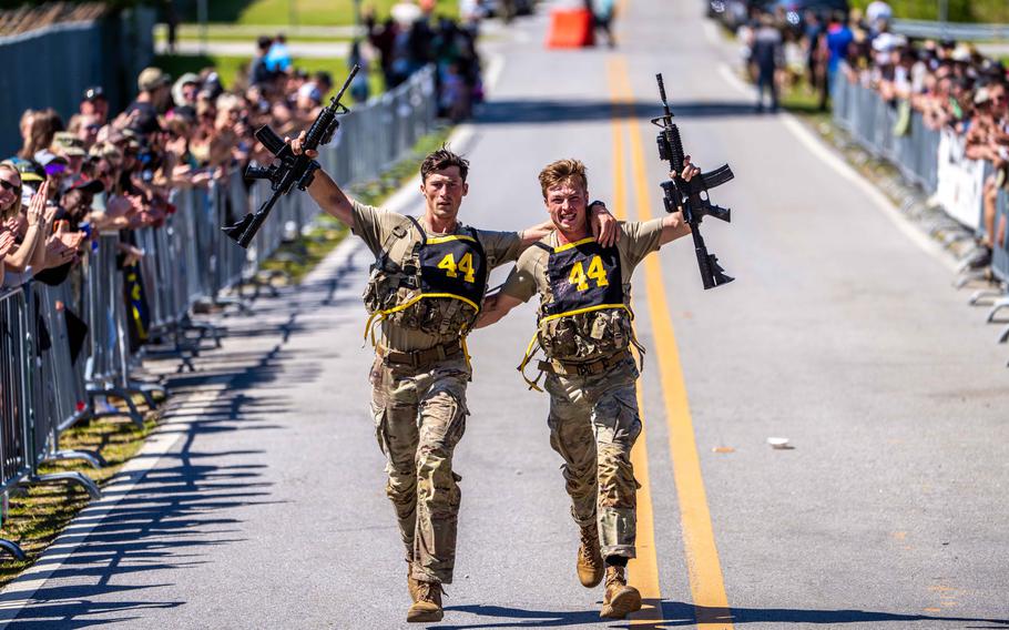 Two soldiers run down a road.