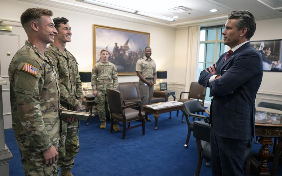Pete Hegseth talks to soldiers in an office.