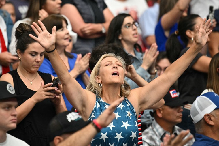 A woman prays during the public memorial service for right-wing activist Charlie Kirk