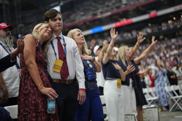 People are overcome with emotion while watching a Charlie Kirk tribute video during a memorial for him Sunday, Sept. 21, 2025, in Glendale, Ariz. 