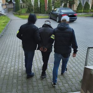 policjanci prowadzą zatrzymanego