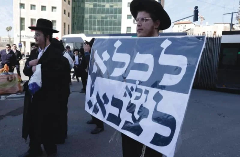 Haredi men are seen protesting the effort to draft ultra-Orthodox Israelis into the IDF. (credit: FLASH90)
