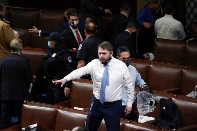 Then-Rep. Ruben Gallego (D-Ariz.) stands on a chair as lawmakers prepare to evacuate the floor as rioters try to break into the House Chamber at the U.S. Capitol on Wednesday, Jan. 6, 2021, in Washington. 