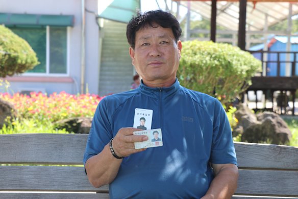 Yugok-ri village head Han Ho-hyeon, 64, shows the pass residents must use to get through a military checkpoint and enter the village.