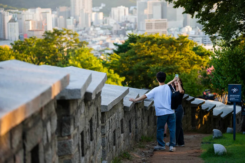 A couple enjoys a date along the historic Seoul City Wall on Naksan, a mountain prominently featured in the film, on Wednesday. - (Jintak Han/The Washington Post)