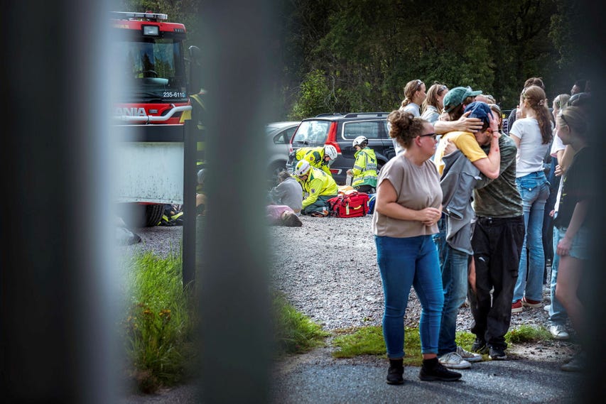 Lärare och elever samlades på uppsamlingsplatsen utanför den fiktiva skolan efter att ha evakuerats av blåljuspersonalen.