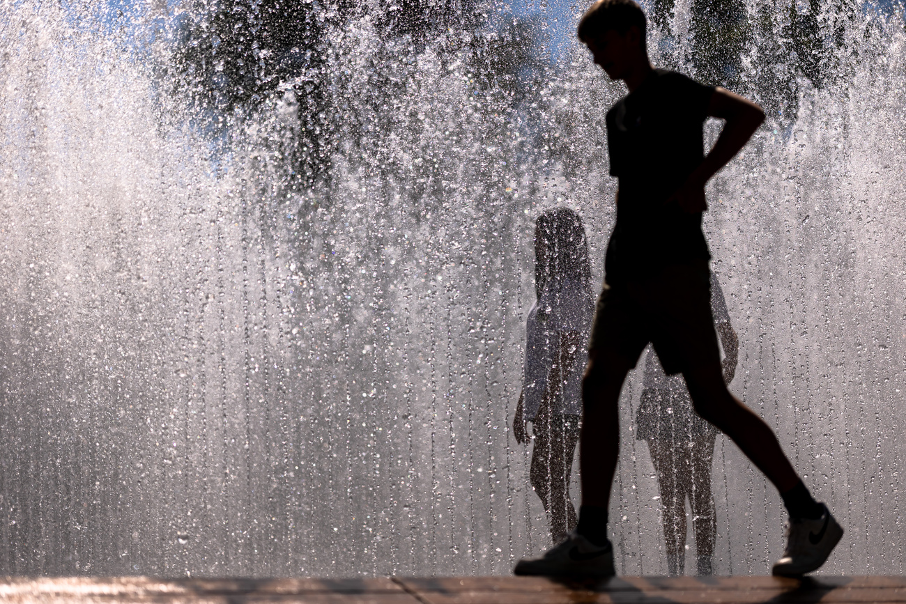 Jugendliche in einem Brunnen im Gegenlicht.