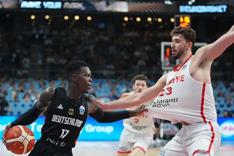 Germany's Dennis Schröder pulls Alperen Şengün's jersey during the EuroBasket final match at Riga Arena in Riga, Latvia, 14 September 2025.