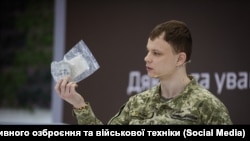 A representative of Ukraine's Center for Research on Captured and Advanced Weapons and Military Equipment, Andriy Rudyk, holds part of a Russian RG-Vo grenade