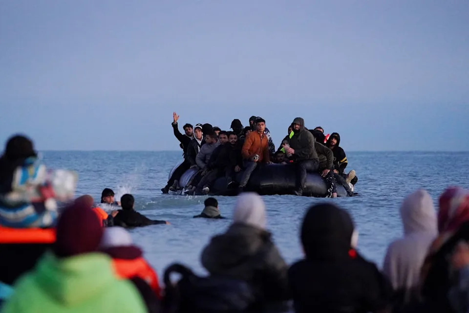 A small boat carrying people thought to be migrants arrives to collect people in Gravelines, France on Friday (PA Wire)