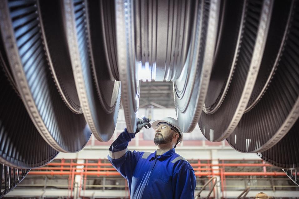 Engineer inspecting a turbine in a  nuclear power station.
