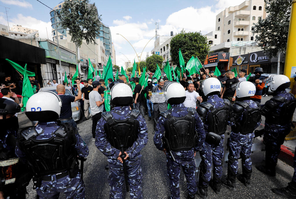 PA police face Hamas supporters in West Bank (Photo: Reuters) שוטרים פלסטינים מול תומכי חמאס בחברון