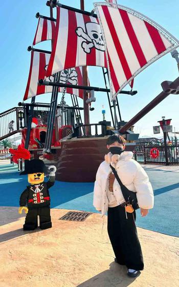 A person poses for a photo in front of one of the attractions in the LEGOLAND Korea.