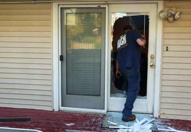 Joe Botello steps through a patio door shattered by federal agents when they broke down the front and back doors of his home in the 900 block of Chippewa Drive in the early morning on Sept. 16, 2025, in Elgin. Botello said the federal agents did not show residents in the home a warrant, placed him in a vehicle, but eventually released him after scanning his driver's license.(Stacey Wescott/Chicago Tribune)
