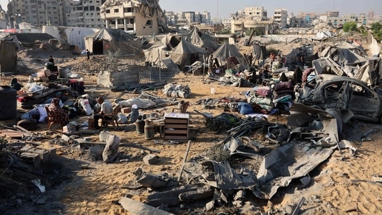 Displaced Palestinians check what remains of their tents, following an overnight Israeli strike that levelled a building and damaged the surrounding temporary shelters, in the Rimal neighbourhood of Gaza City.(Omar al-Qattaa/AFP) Displaced Palestinians check what remains of their tents, following an overnight Israeli strike that levelled a building and damaged the surrounding temporary shelters, in the Rimal neighbourhood of Gaza City.(Omar al-Qattaa/AFP)