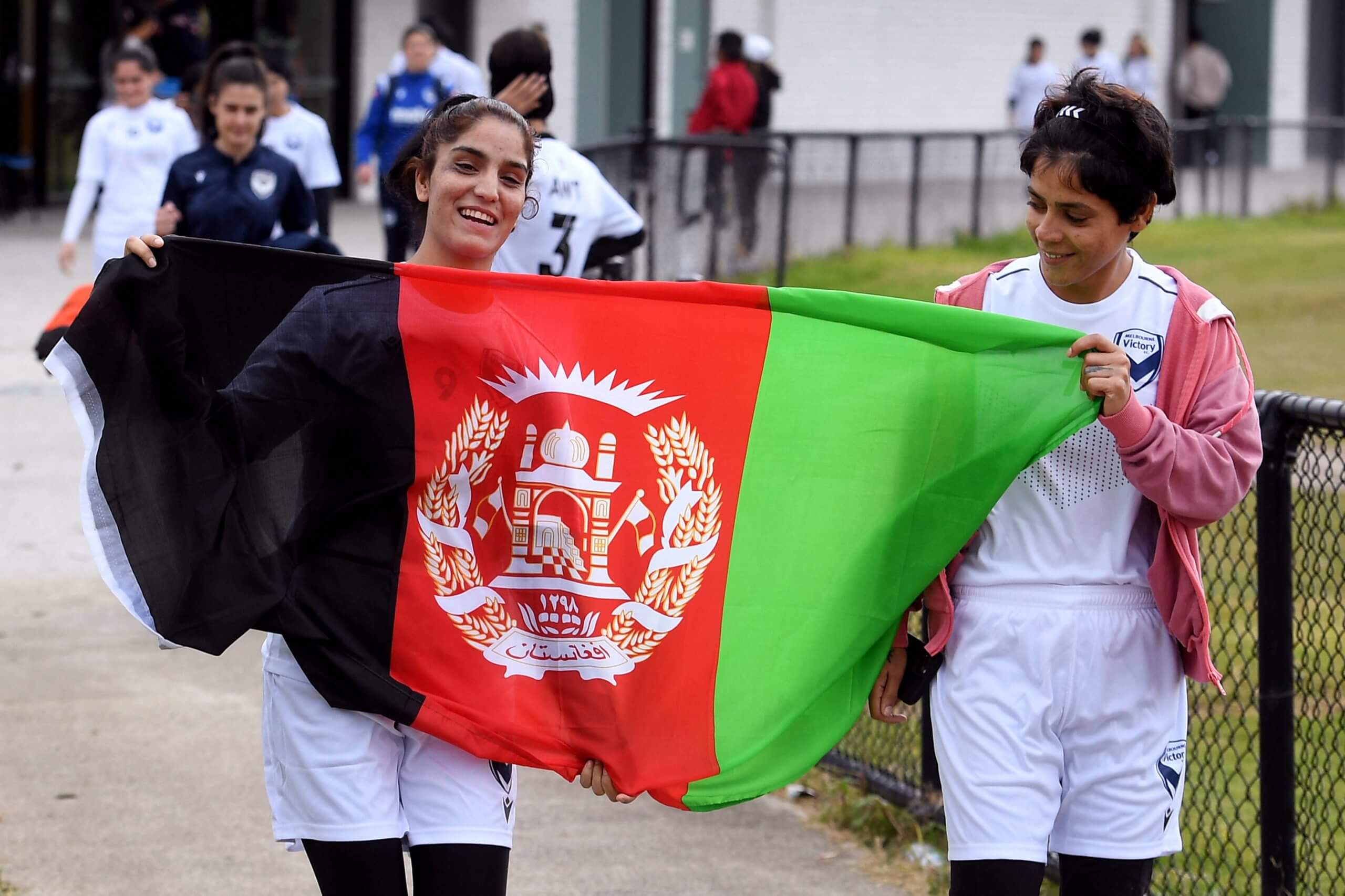 Members of the Melbourne Victory Afghan women's team carry the Afghanistan flag before their first match in a local league in April 2022 (Photo: William West/AFP via Getty Images)