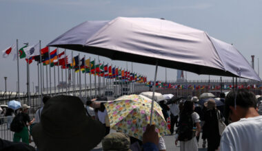 People shield themselves from the sun during a heat wave on Aug. 27 in Osaka, Japan. As deadly heat waves kill tens of thousands worldwide annually, the United Nations Environmental Programme has started controversial discussions about concepts to build an atmospheric umbrella for the Earth. Credit: Buddhika Weerasinghe/Getty Images