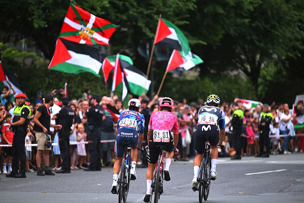 Cyclists pass Palestine flags at La Vuelta a España.