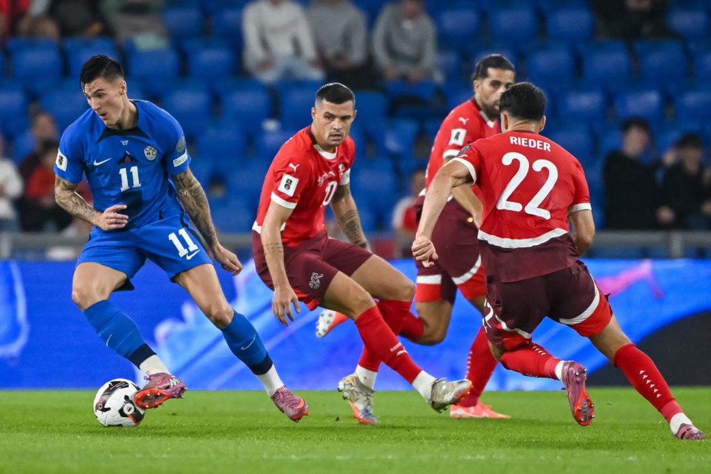 Slovenia's forward #11 Benjamin Sesko (L) controls the ball