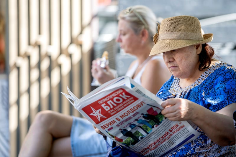 A woman reads an electoral newspaper in Chisinau, Moldova. Photograph: EPA
