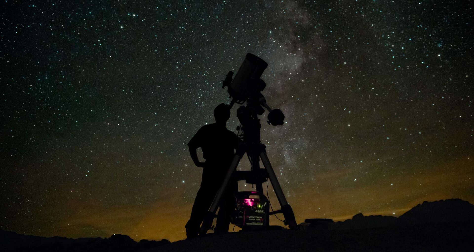 Astronomer using telescope to observe the night sky