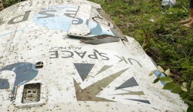 A white metal piece of space debris lies on a grassy lawn with the words &quot;UK Space&quot; upside down with the logo.