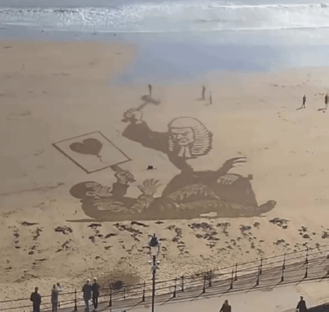Recently removed Banksy peice redrawn on a beach in Scarborough