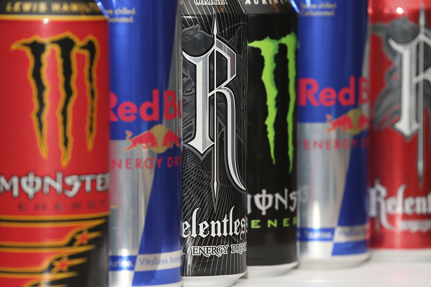 Various red, blue and black cans of energy drinks.