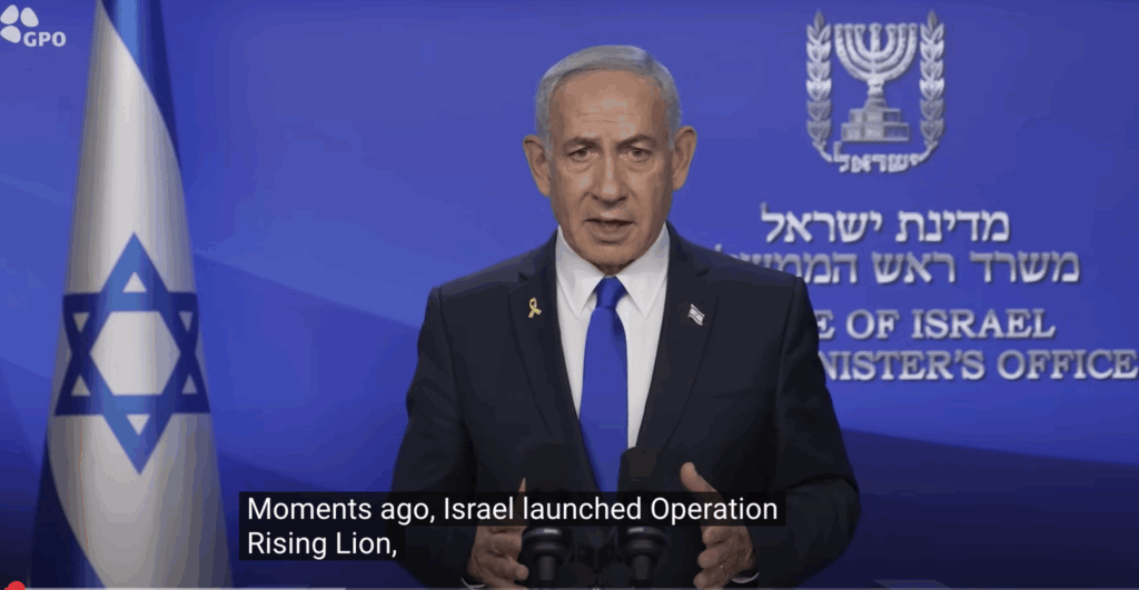 Israeli official giving a televised statement at a podium with the Israeli flag and government insignia in the background; caption mentions Operation Rising Lion.