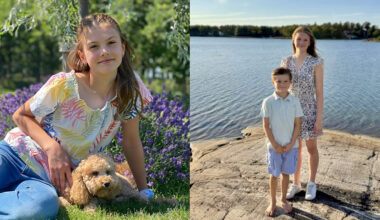 Princess Estelle posing in grass with a curly brown dog; Princess Estelle wearing a floral dress and Prince Oscar in shorts and a polo standing in front of a lake