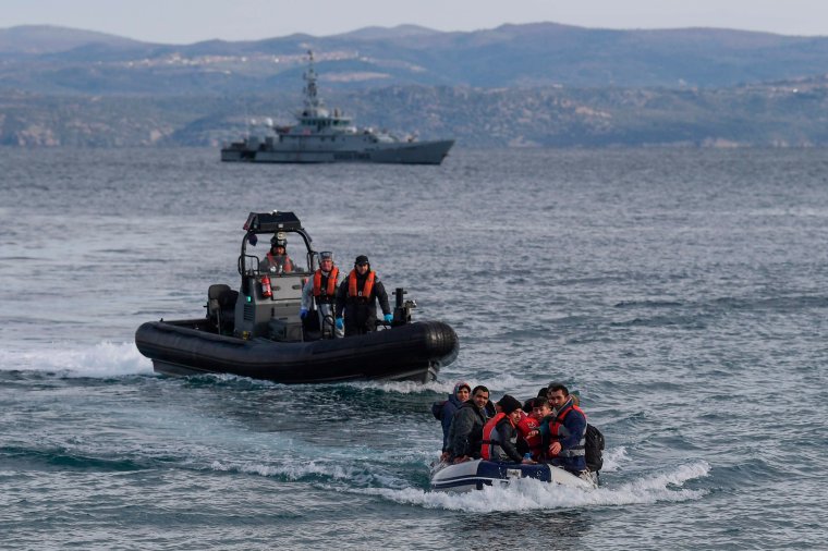 A dinghy with 15 Afghan refugees, 5 children, 3 women and 7 men, approaches the Greek island of Lesbos on February 28, 2020 next to UK Border Force patrol boat HMC Valiant (background), a cutter patroling in Agean sea under European Union border force Frontex. - Turkey will no longer close its border gates to refugees who want to go to Europe, a senior official told AFP on February 28, shortly after the killing of 33 Turkish soldiers in an airstrike in northern Syria. (Photo by ARIS MESSINIS / AFP) (Photo by ARIS MESSINIS/AFP via Getty Images)
