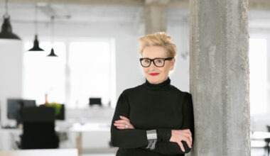Portrait of elegant older businesswoman standing in the modern studio, smiling at the camera.
