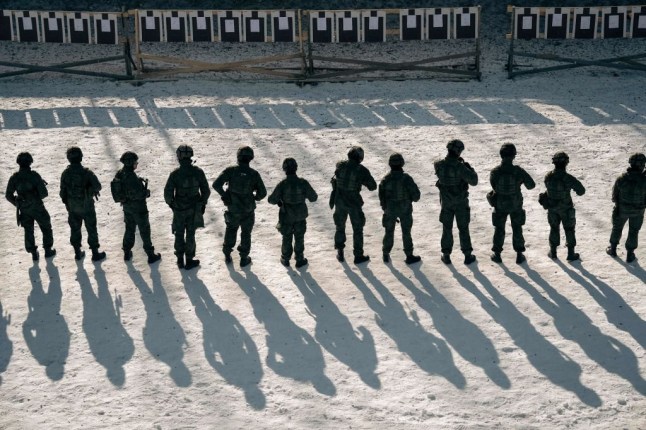 TOPSHOT - Finnish reservists of the Guard Jaeger Regiment stand at a shooting range as they take part in a military exercise at the Santahamina military base in Helsinki, Finland on March 7, 2023. - When Russia invaded Ukraine, a new iron curtain severed once-close ties between Moscow and Helsinki. More than a century after its independence from Russia and three decades after joining the EU, the country of 5.5 million people is now forging a new foreign policy identity -- cementing its ties with the West as it takes its final steps toward NATO membership. On the military island of Santahamina in Helsinki, young reservists fill their assault rifle magazines with their bare hands in temperatures dipping to minus 15 degrees Celsius (5 degrees Fahrenheit), as the white snow reflects the blinding sunlight. In the most visible sign of this new era, Finland ended its decades-long policy of military non-alliance when it applied to join NATO in May 2022. (Photo by Alessandro RAMPAZZO / AFP) (Photo by ALESSANDRO RAMPAZZO/AFP via Getty Images)