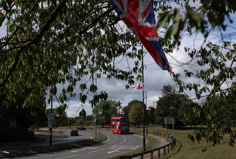 Flags of England, with St. George's Cross, hang from lamp posts as a Union Jack hangs from a tree, in West Drayton near London, Britain September 1, 2025. REUTERS/Hannah McKay