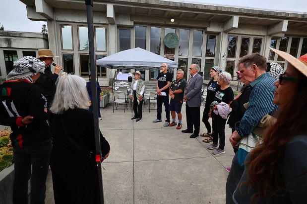 Peter Klotz-Chamberlin, with microphone, begins Friday's vigil where the names of the children killed in Gaza were read. (Shmuel Thaler - Santa Cruz Sentinel)