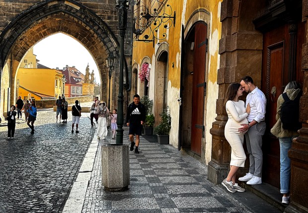 A couple enjoys an intimate moment near the gate to...