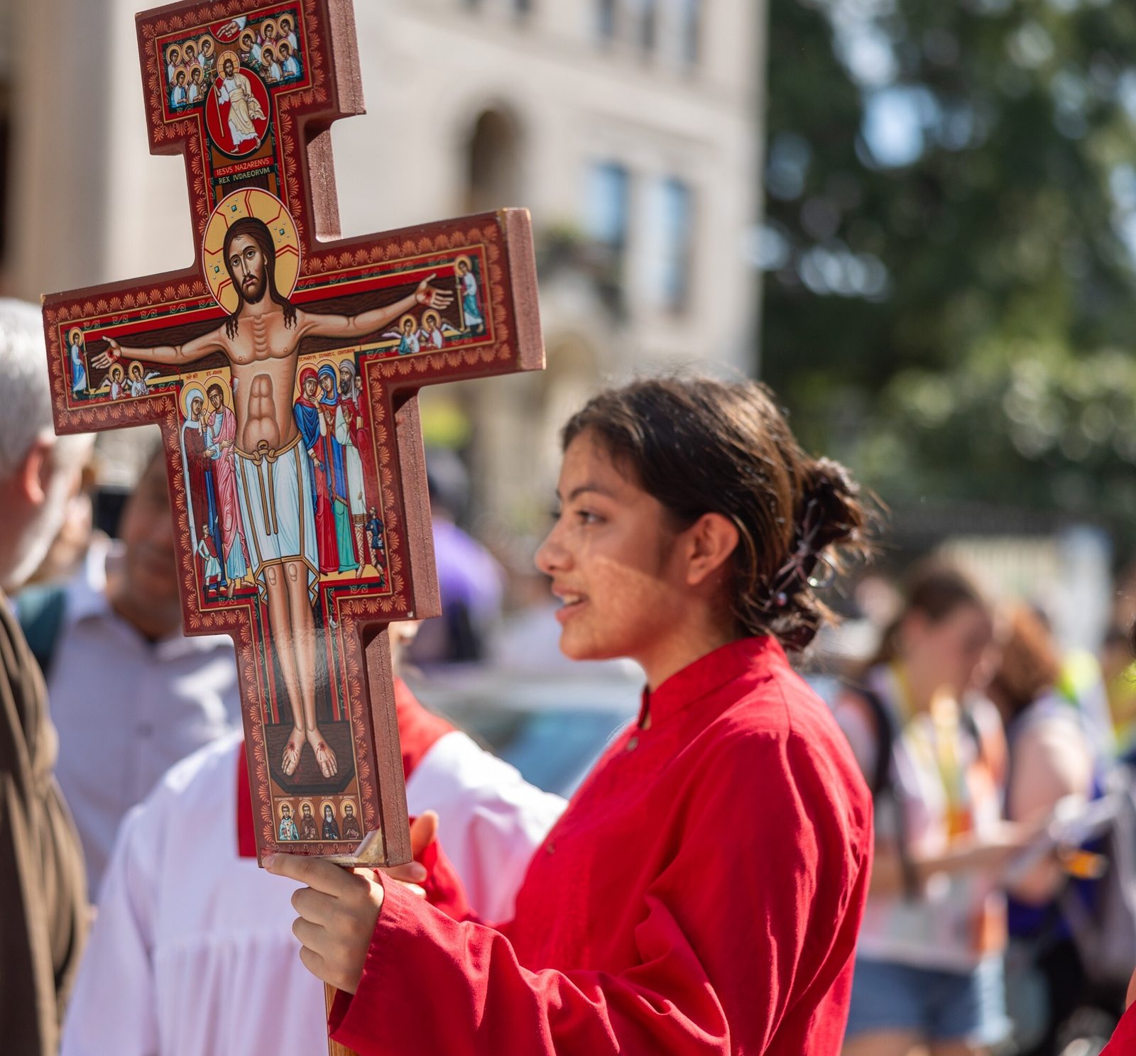 A young woman holds a San Damiano Cross as the procession for the 111th World Day of Migrants and Refugees was about to begin at the Shrine of the Sacred Heart in Washington, D.C., on Sept. 28, 2025. (Catholic Standard photo by Mihoko Owada)