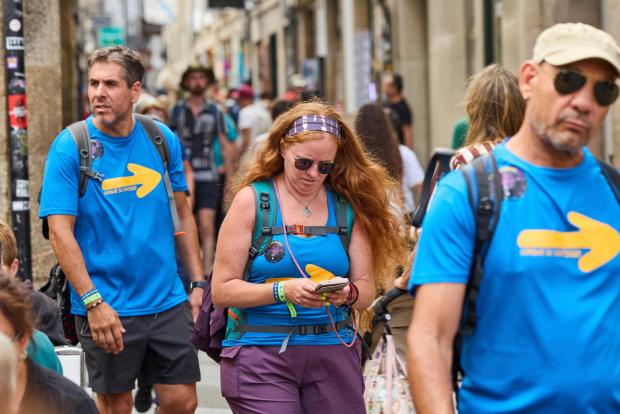 Pilgrims walk in Santiago de Compostela downtown, northwestern Spain, Thursday, Aug. 21, 2025. (AP Photo/Lalo Villar)