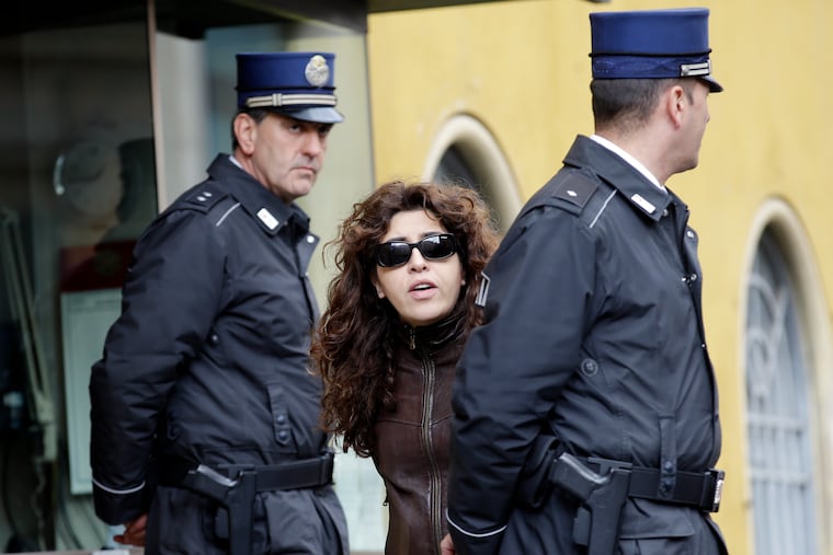 FILE - Public relations expert Francesca Chaouqui walks past two Vatican Gendarmi as she leaves the Vatican during a pause of her trial, March 15, 2016. (AP Photo/Andrew Medichini, File)