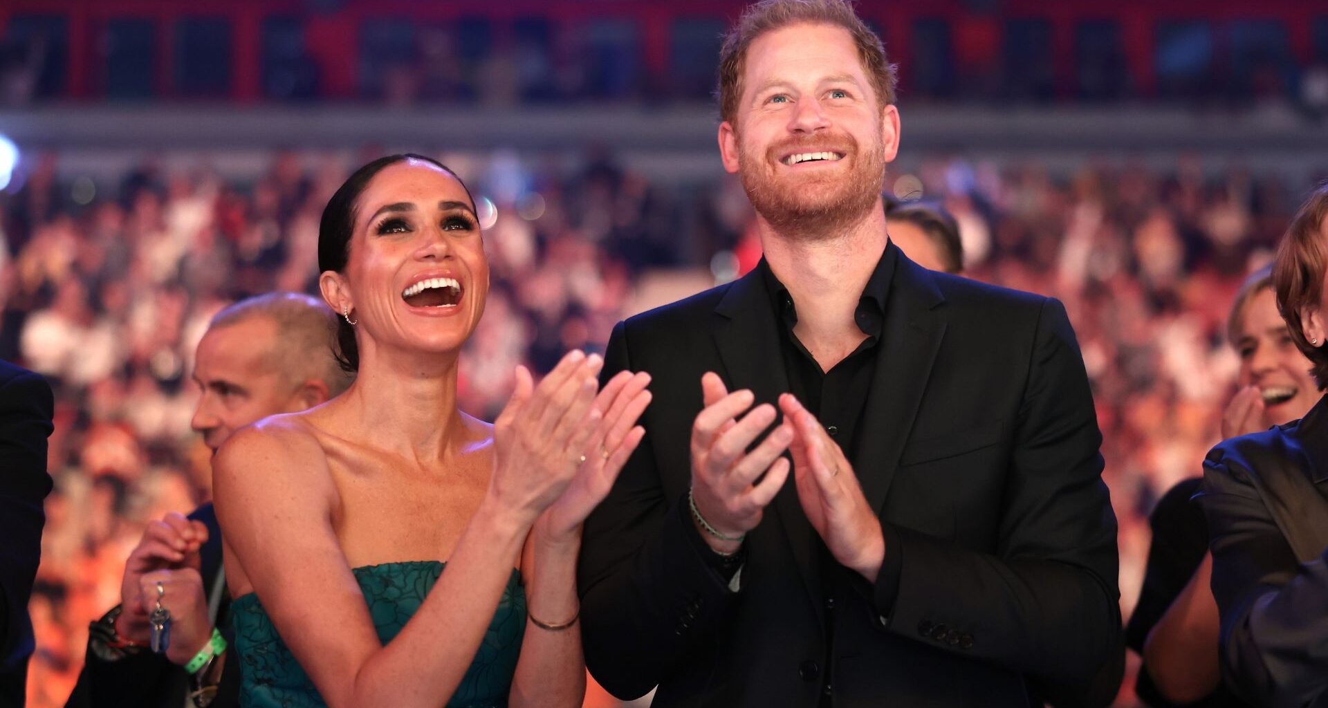 Meghan Markle and Prince Harry clapping and cheering together
