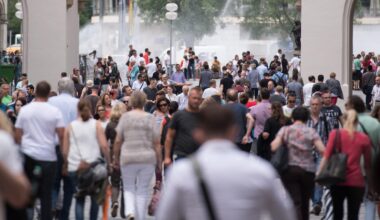 Passanten gehen durch eine Fußgängerzone in München.