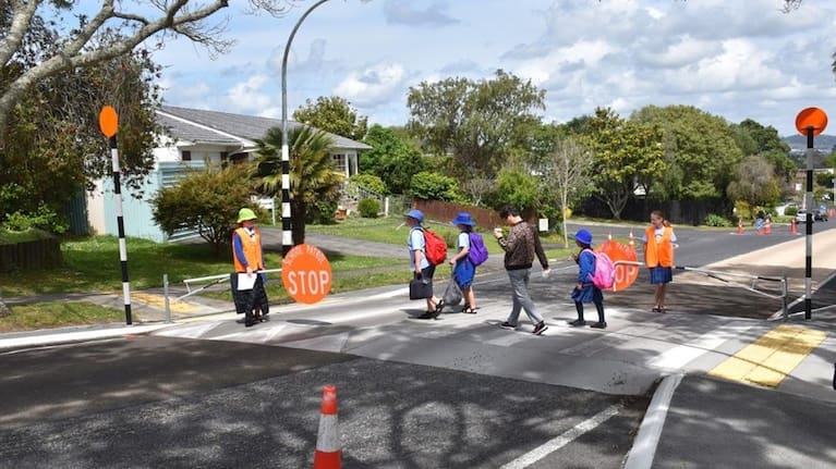 Children cross a busy road in Manurewa where roaming dogs have become a growing concern.
