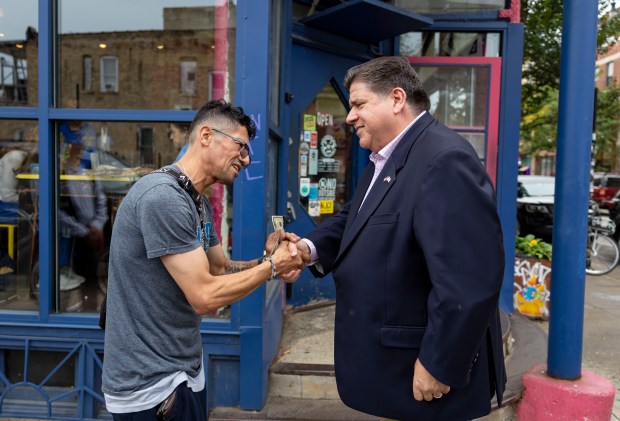 Antonio Cacho, who is originally from Mexico, thanks Gov. JB Pritzker for his work, Sept. 3, 2025, outside Jumping Bean Cafe in the Pilsen neighborhood of Chicago. (Brian Cassella/Chicago Tribune)